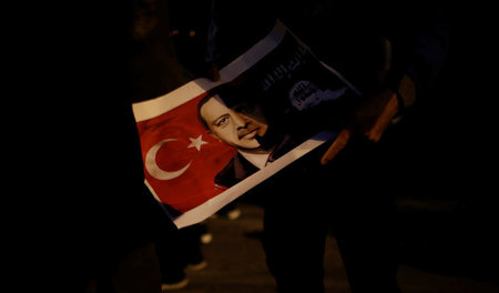 Ein kurdischer Demonstrant mit einem Bild des türkischen Präside...
