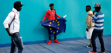 Afrikaner mit der Flagge der EU in einem Übergangslager für Flüc...