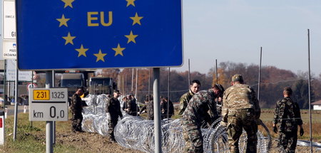 Soldaten plazieren Stacheldraht an der Grenze zwischen Slowenien...