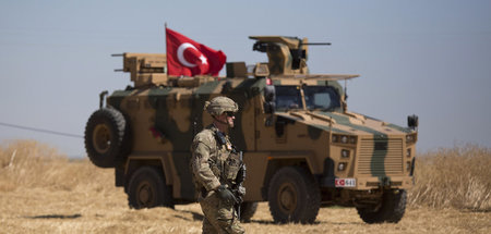 Ein US-Soldat vor einem türkischen Panzerfahrzeug im syrischen T...