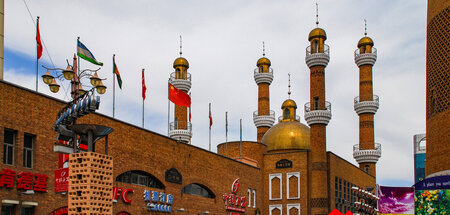 Rote Fahnen neben Minaretten. Das Zentrum von Ürümqi, Hauptstadt...