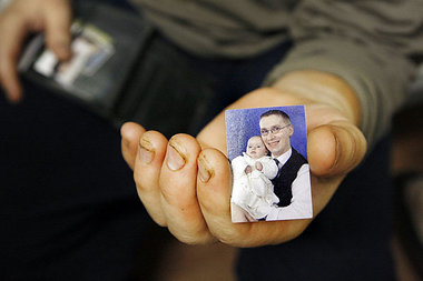 Zu Hause wartet die Familie – ein Arbeiter mit dem Foto seiner T...