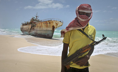 Somalischer Pirat vor einem gekaperten und nach Lösegeldzahlung ...
