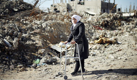 Manar Al-Schinbari vor den Trümmern ihres Hauses, das bei einem ...
