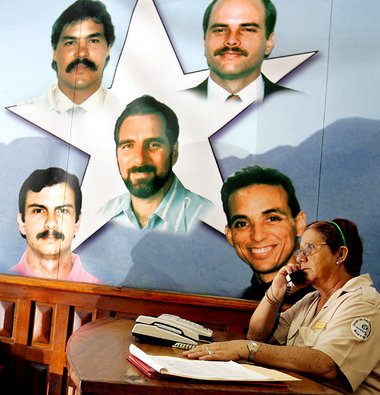 Regierungsangestellte in Havanna vor den Portraits der fünf Gefa...