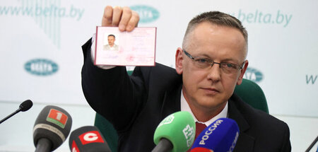 Tomasz Szmydt zeigt seinen Personalausweis auf einer Pressekonfe...