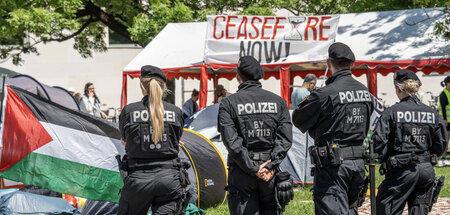 Beamte der bayerischen Polizei stehen am Rande des Protestcamps ...