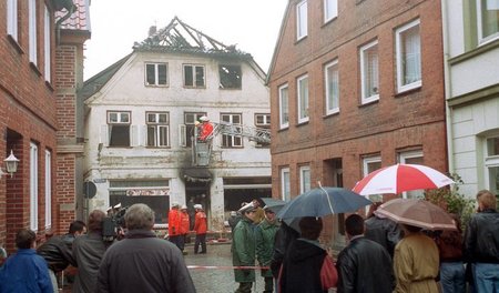 Am Morgen nach der Mordnacht: Feuerwehrleute sichern das ausgebr...