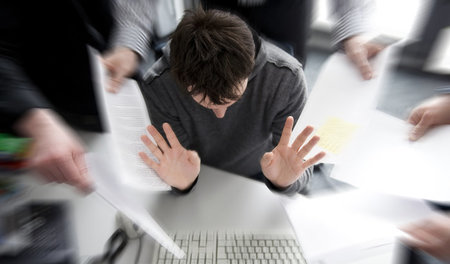 Gestresst im Büro: Ein Beschäftigter sieht sich mit zu vielen An... Gestresst im Büro: Ein Beschäftigter sieht sich mit zu vielen An...