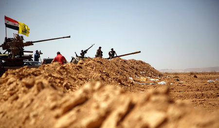 Fahnen der Hisbollah und Syriens wehen auf einem Militährfahrzeu...