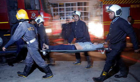 Feuerwehrleute mit einem geborgenen Opfer des Brandes am 29. Dez... Feuerwehrleute mit einem geborgenen Opfer des Brandes am 29. Dez...
