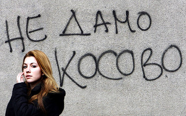 Eine Serbin vor einem Graffito in Belgrad: »Wir geben Kosovo nic...