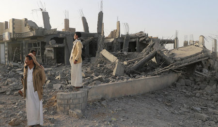 Menschen in den Ruinen des Außenbezirks der Stadt Saada im Jemen...