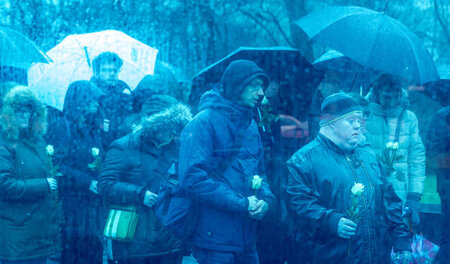 Teilnehmer der Gedenkveranstaltung trugen am Mittwoch ihre weiße...