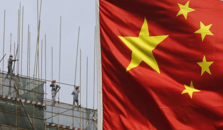 Aufbau einer neuen Gesellschaft. Arbeiter hinter chinesischer Fl...