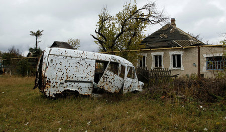 Kriegsschäden in Donezk: Ein zerschossener Kleintransporter am S...