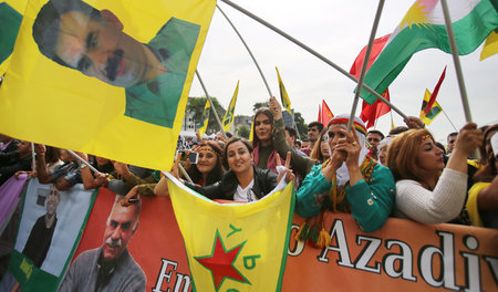 In Bayern kriminalisiert: Demonstrantinnen mit YPG-Fahne und Por... In Bayern kriminalisiert: Demonstrantinnen mit YPG-Fahne und Por...