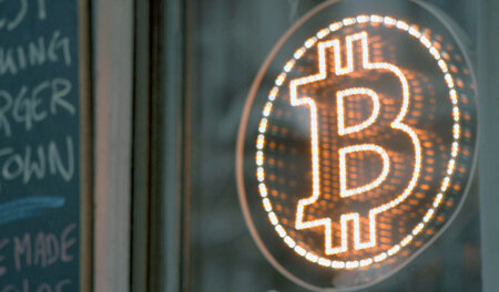 Das Logo an der Fensterscheibe verrät: Hier kann mit Bitcoin bez...