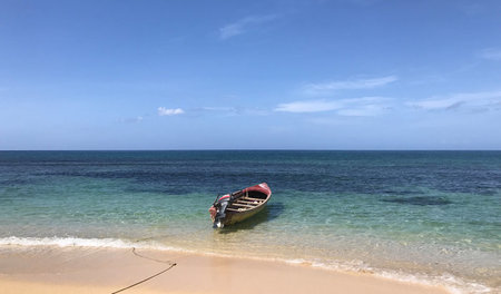 Strandidylle mit einsamem Boot nahe des bei Touristen beliebten ...