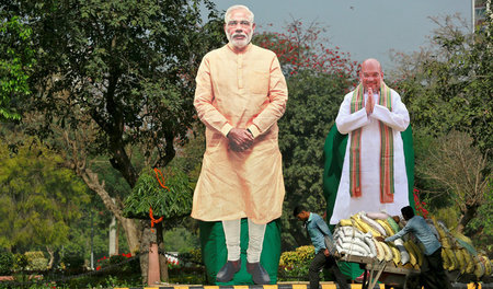 Aufstellfiguren vom indischen Premierminister Narendra Modi (l) ...