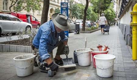 Der Künstler Gunter Demnig beim Verlegen eines Stolpersteins in ...
