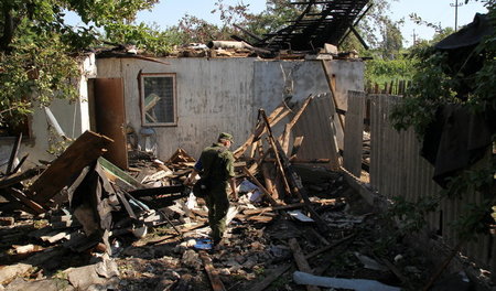 Soldat der »Volksrepublik« Donezk in den Trümmern eines von Kiew...