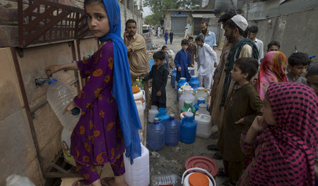 Viele Menschen müssen in Pakistan für sauberes Trinkwasser Schla...