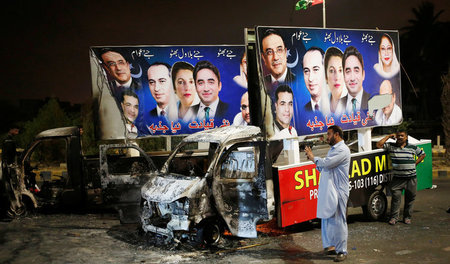 Wahlkampf gewaltförmig. Ausgebrannter Lastwagen mit Wahlplakaten...
