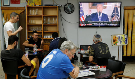 Israelis in einem Café in Aschkelon während einer im Fernsehen ü...