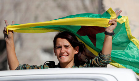 Kämpferin der SDK mit dem Banner der syrisch-kurdischen Frauenve...