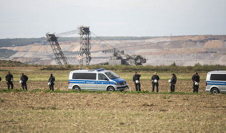 Eine Polizeikette sperrt den Tagebau Hambach ab. Die Reste des F...