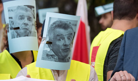 Ryanair-Beschäftigte während eines Warnstreiks mit Masken des Vo...