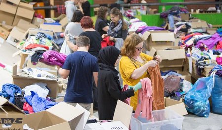 Praktische Solidarität: Flüchtlingshelfer sortieren Kleiderspend...