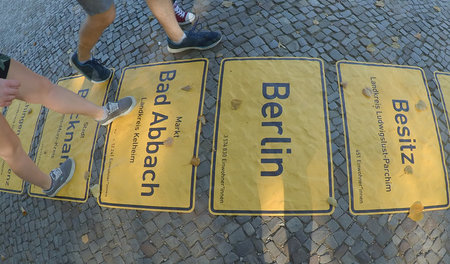 Ortsschilder zum »Tag der deutschen Einheit« auf der Straße des ... Ortsschilder zum »Tag der deutschen Einheit« auf der Straße des ...