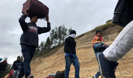Venezolanische Migranten auf einem Highway in Tulcan/Ecuador auf...