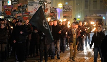 Mit Fackeln und Transparenten versammeln sich extrem rechte Demo...