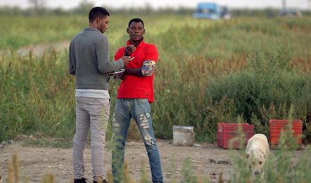 Yvan Sagnet (l.) mit einem Erntehelfer vor dem »Ghana-Ghetto«: »...