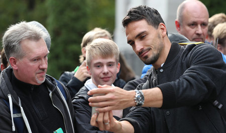 Hinter vorgehaltener Hand zeigt Hummels (r.), was er wieder getw...