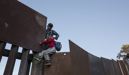Ein Mann hebt sein Kind am 2. Dezember im mexikanischen Tijuana ... Ein Mann hebt sein Kind am 2. Dezember im mexikanischen Tijuana ...
