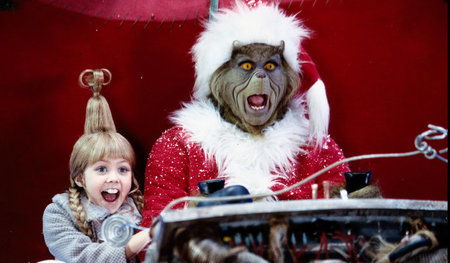 Der Grinch und Cindy Lou sitzen vor einer Maschine mit Schaltheb...