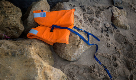 Eine Schwimmweste auf einem Felsen an der spanischen Küste (Nove...