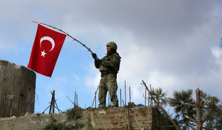 Invasion in Syrien: Ein Soldat schwenkt die türkische Fahne auf ...