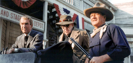 (v.l.n.r.): James Stewart, John Ford und John Wayne beim Dreh vo