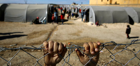 Ein kurdischer Flüchtling aus Kobani am Zaun des Lagers in Suruc...