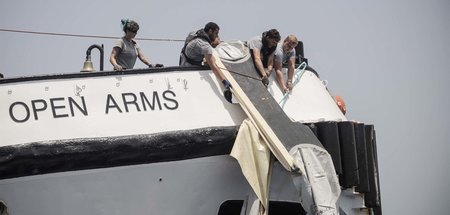 Seenotretter der »Open Arms« ziehen Teile eines Schlauchboots an...