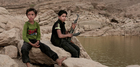 Jugendliche mit Waffe am Staudamm in Marib (Jemen). Kindersoldat