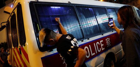 Ein Protestierender schlägt in Hongkong mit der Faust gegen eine...