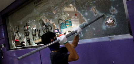 Ein Demonstrant zerstört die Scheiben einer U-Bahn-Station in Ho...