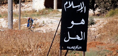 Ein syrischer Soldat neben einem Schild mit der Aufschrift »Der ... Ein syrischer Soldat neben einem Schild mit der Aufschrift »Der ...