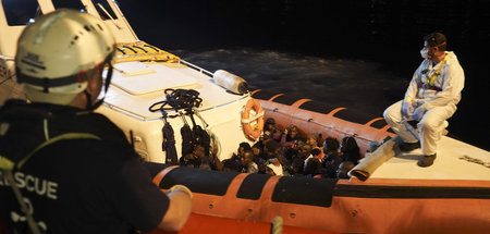 Migranten in einem Boot der italienischen Küstenwache, nachdem s...